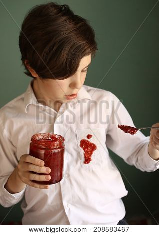 teenager untidy boy drop jam from jar to white shirt make dirty spot close up photo