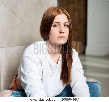 Portrait of young ginger-haired girl looking at camera.