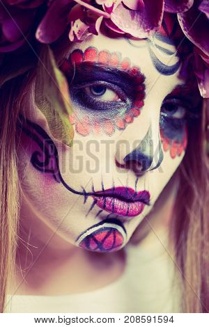Closeup portrait of Calavera Catrina. Young woman with sugar skull makeup. Dia de los muertos. Day of The Dead. Halloween.
