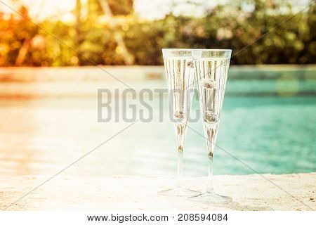 Two Glasses Of Prosecco  Cocktail With Blueberries At The Edge Of A Resort Pool. Concept Of Luxury V