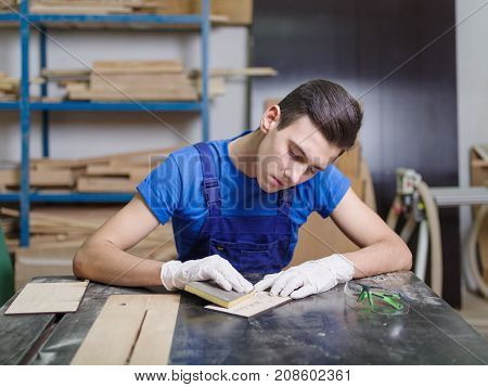 A carved plate on which the patterns and inscriptions are burned out that the master in blue overalls handle with a special tool
