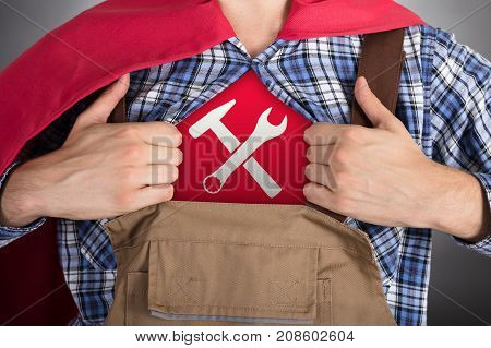 Close-up Of Superhero Handyman Opening Shirt For Showing Worktools Sign