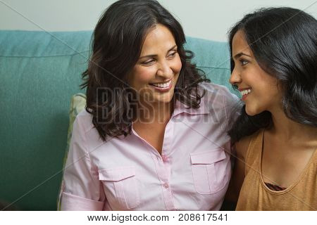 Mother talking and laughing with her teenage daughter.