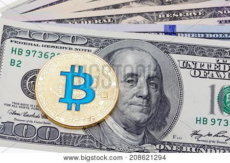 A few hundred dollar banknotes with golden cruptocurrency bitcoin on white background.  High resolution photo.