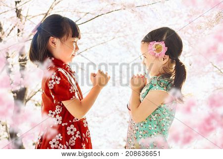 Two adorable girl wearing cheongsam during chinese new year season .