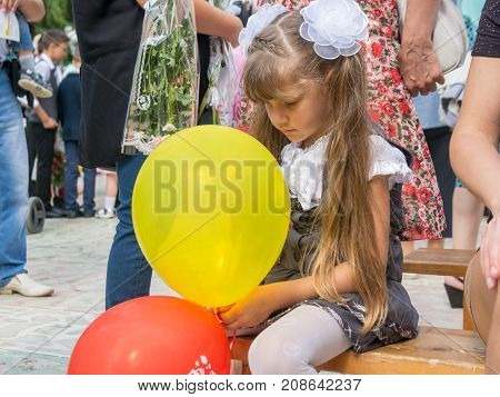 Sad girl sitting with balls in hands on September 1 holiday