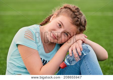A young bright girl loves sports.closeup portrait of young girl holding clean water