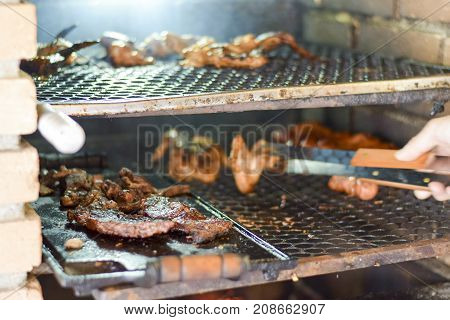 Brazilian Man Tending To Churrasco