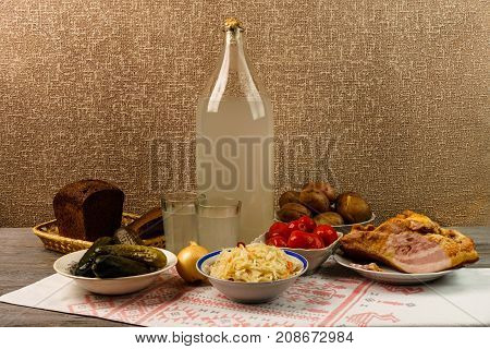 Ukrainian National Drink And Snack. The Big Bottle And Glass Of Moonshine On The Old Wooden Table