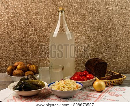 Ukrainian National Drink And Snack. The Big Bottle And Glass Of Moonshine On The Old Wooden Table