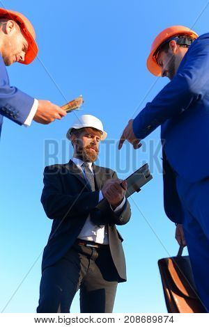 Workers And Engineers Hold Meeting On Blue Sky Background