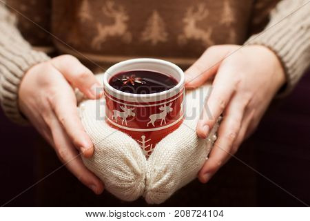 couple holding swedish glogg or mulled wine in hands. Deer moose pattern on a background.