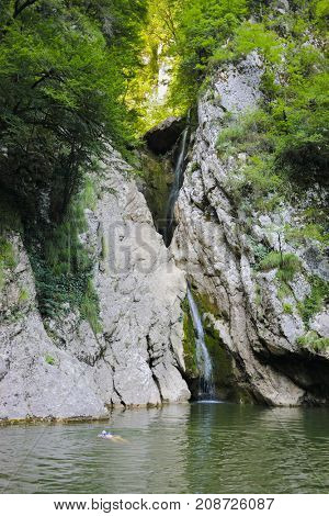 woman bathing in river Agura near waterfall Devils in Sochi, Krasnodar Krai, Russia