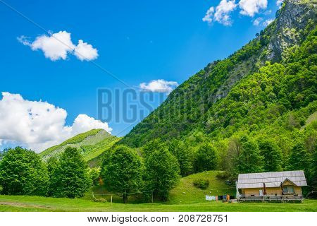 The House Of Wooden Logs Stands Alone In The Middle Of The Mountains.