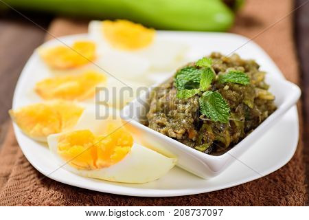 Northern Thai food (Tum Makeua Yao),grilled green eggplant pounding with chili and spices, eating with boiled egg