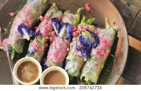 Salad flower roll with sauce.Lettuce, Butterfly pea and Mexican Creeper, Fresh vegetable noodle spring roll.