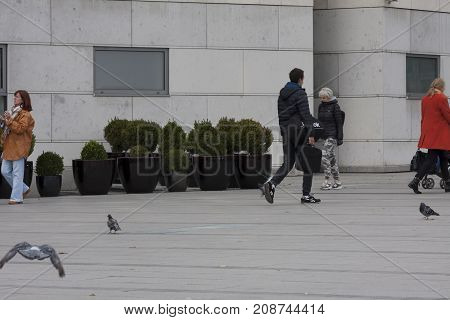 Fragment of shopping centre main square Cracow Poland - October 13 2017: People are walking through square the pigeons are looking for some food near Galeria Krakowska shopping centre Cracow Poland.