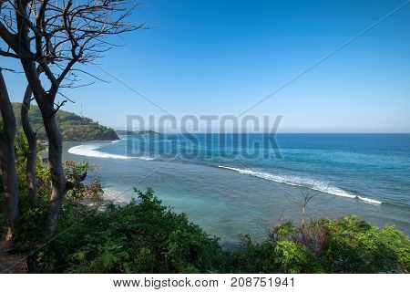 Beautiful landscape of blue beach with white sand and palm trees in Senggigi Beach at Lombok island West Nusa Tenggara Indonesia