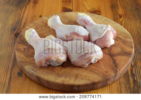 Raw Chicken Legs On Olive Wooden Board