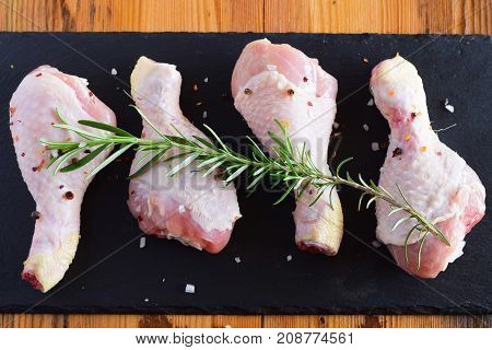 Raw Chicken Legs On A Black Slate