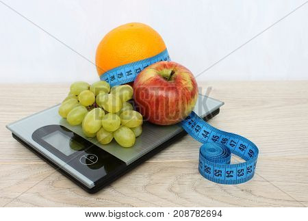 Fruits are apple orange grapes and meter on electronic scales. Diet.