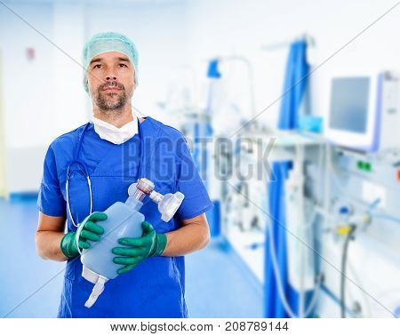 young anesthetist with resuscitation bag in front of clinic background