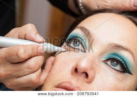 Makeup Artist Cleaning And Giving The Final Touches To Cat Eyes Makeup