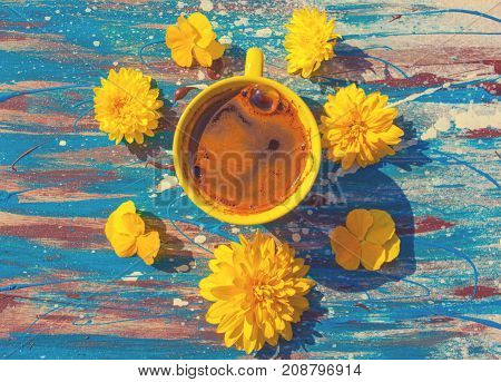 yellow сup with tea or coffee yellow flowers around