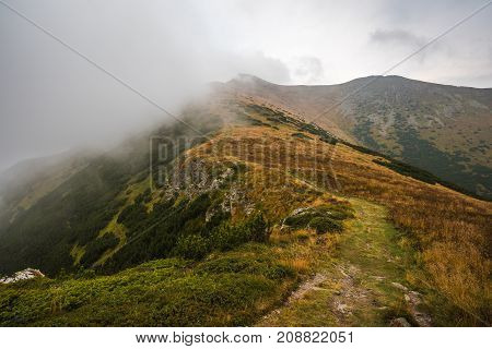Hiking Trail on the Hill with Fog in the Mountains on Overcast Day
