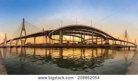 Sunset over double suspension bridge with highway interchanged river front