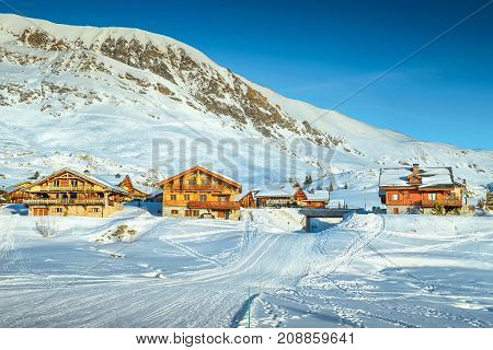 Wonderful winter landscape with wooden chalets and ski slopes in French Alps Alpe D Huez France Europe