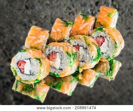 Roll with salmon, strawberry and creamcheese ocer concrete background