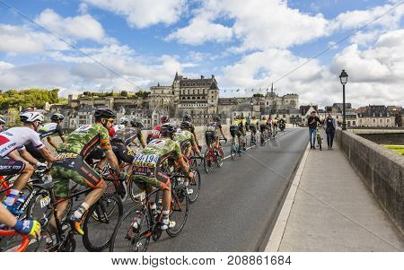 AmboiseFrance - October 82017: The peloton passing on the bridge in front of Amboise Castle during the Paris-Tours road cycling race.
