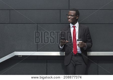 Urban Closeup Of Young African Male Standing With Grey Wall Behind Him Having Break From Business Me
