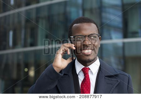 Urban Image Of Handsome African Entrepreneur Spending Break Outside High City Building Looking Aside