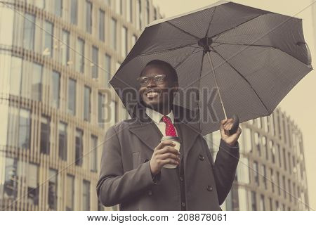 Urban Portrait Of Handsome African American Businessman Standing In City Center In Cloudy Weather Un