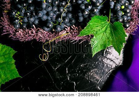 Red Wine Grapes In Voiolet Basket On Bllack Background.