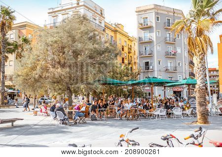 BARCELONA, SPAIN - August 16, 2017: View on the old buildings and coastline bars and restaurants full of people on Barcelonetas beach in Barcelona
