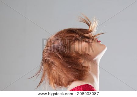 Pleasant feeling. Female hairstyle advertising, hair in motion. Creative woman haircut closeup on grey background with free space, pleasure concept