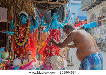 KUMARTULI KOLKATA INDIA - OCTOBER 10 2014 - Artist preparing clay idol to be worshipped as Goddess Kali during Kali Puja Hindu festival of Deepavali or Diwali. Celebtated all over India.