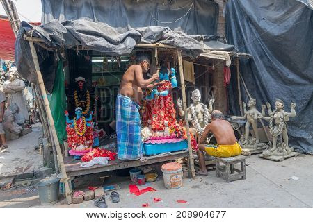 KUMARTULI KOLKATA INDIA - OCTOBER 10 2014 - Artist preparing clay idol to be worshipped as Goddess Kali during Kali Puja Hindu festival of Deepavali or Diwali. Celebtated all over India.
