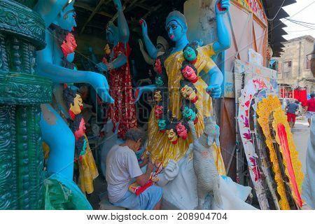 KUMARTULI KOLKATA INDIA - OCTOBER 10 2014 - Artist preparing clay idol to be worshipped as Goddess Kali during Kali Puja Hindu festival of Deepavali or Diwali. Celebtated all over India.