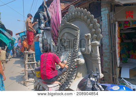 KUMARTULI KOLKATA INDIA - OCTOBER 10 2014 - Artist preparing clay idol to be worshipped as Goddess Kali during Kali Puja Hindu festival of Deepavali or Diwali. Celebtated all over India.