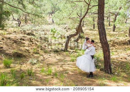 Just married couple embraced on nature. Bride and groom.
