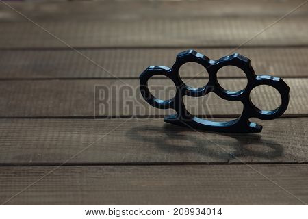 Brass knuckles on a beautiful brown wooden background.