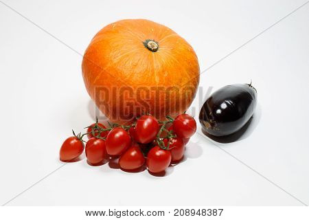 Pumpkin and juicy cherry tomatoes on a white background