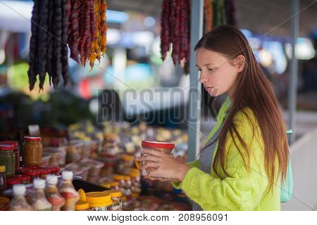 Young woman at the bazaar buying food ingridients.