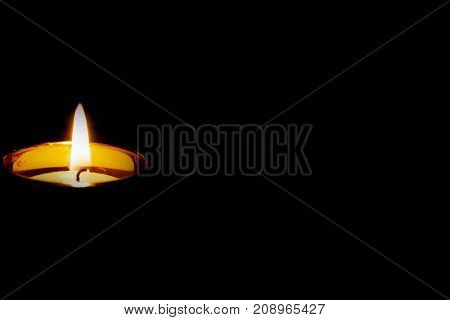 Mourning concept.The onle one fired candle on  black background.