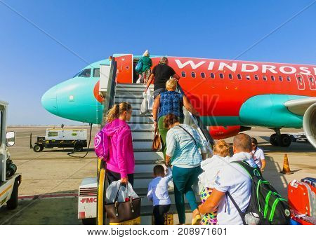 Sharm El Sheikh, Egypt - September 28, 2017: The passenger walking to the rear entrance of airplane at day at Sharm El Sheikh, Egypt on September 28, 2017