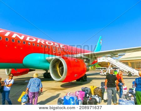 Sharm El Sheikh, Egypt - September 28, 2017: The passenger walking to the rear entrance of airplane at day at Sharm El Sheikh, Egypt on September 28, 2017